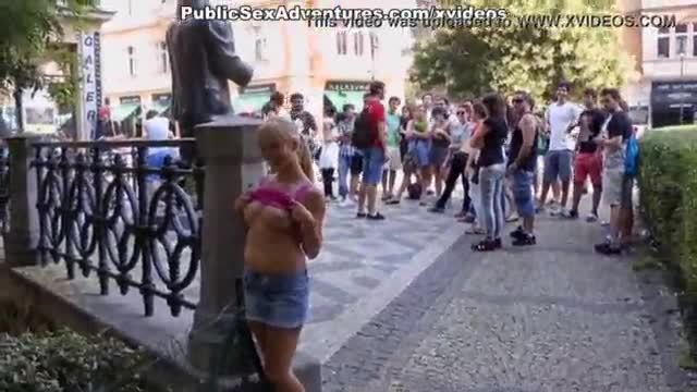 Sexy girl shows tits in the middle of a lively square
